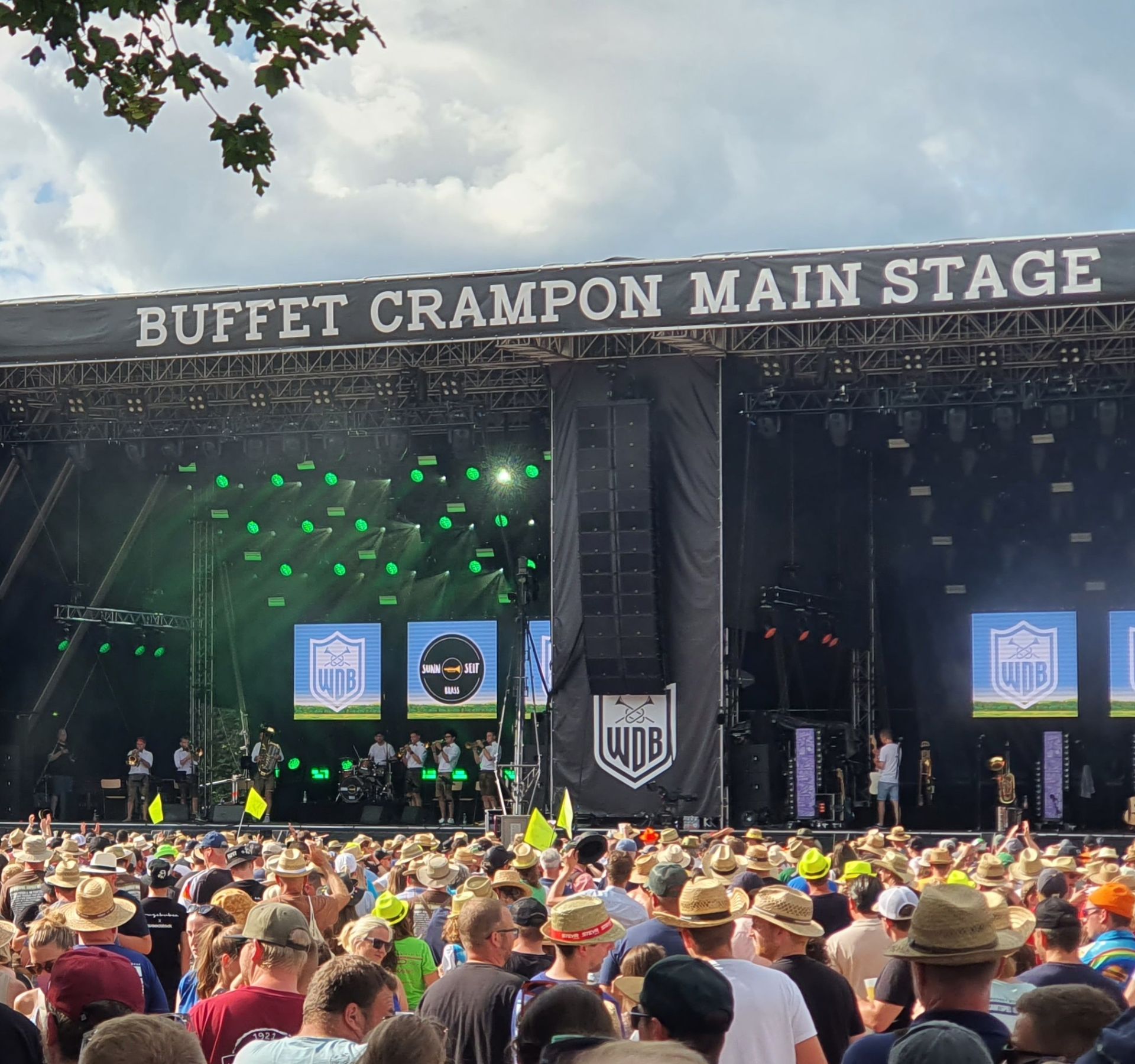 Vor einer großen Festival-Bühne stehen sehr viele Menschen im Freien.