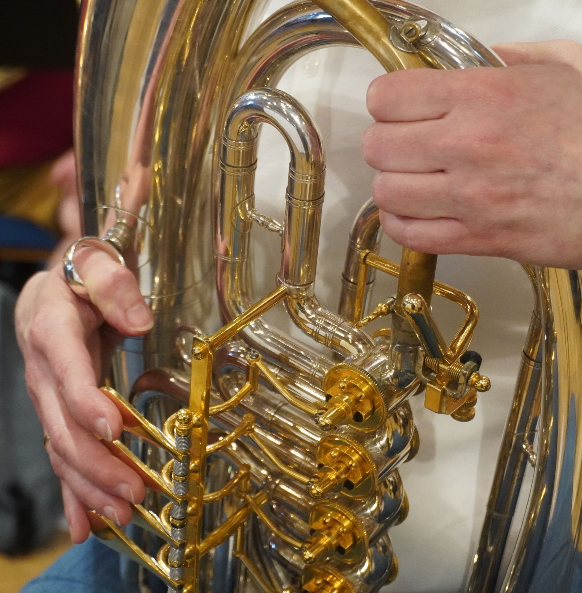 Nahaufnahme der Hände einer Person, die Tenorhorn spielt. 