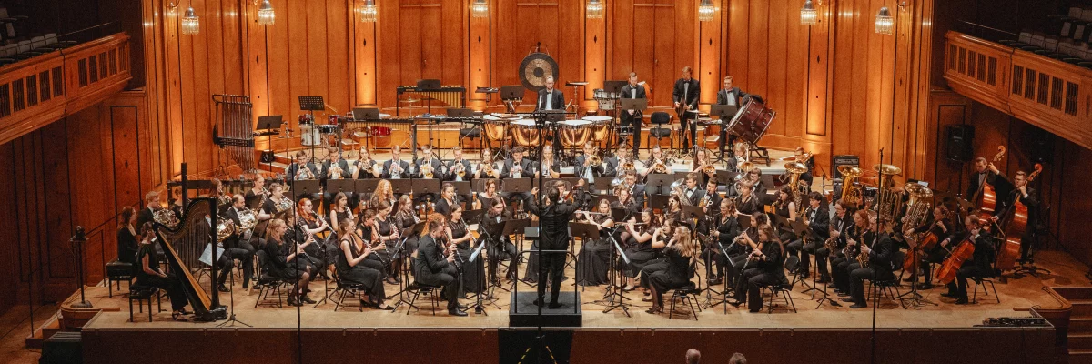 Ein großes Orchester sitzt in einem edlen Konzertsaal.