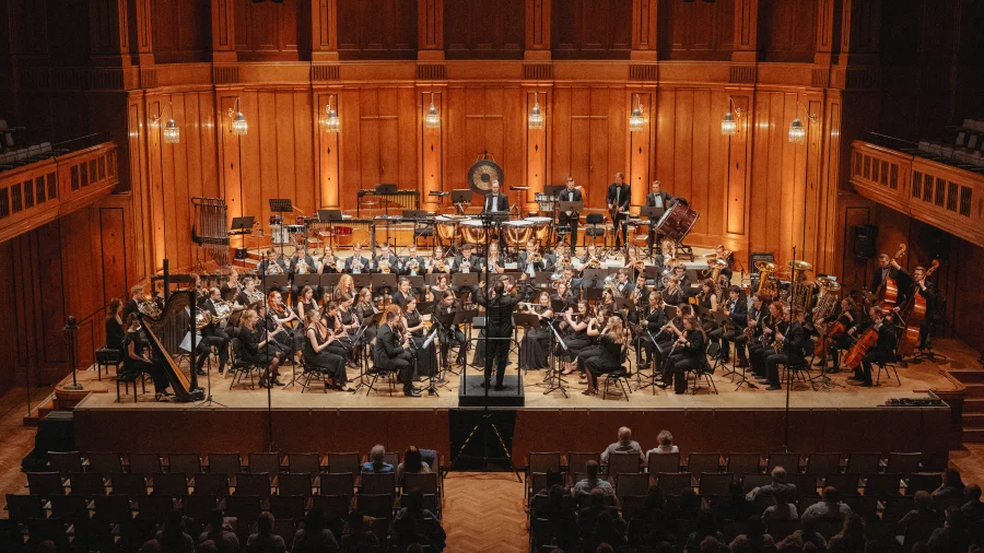 Ein großes Orchester sitzt in einem edlen Konzertsaal.